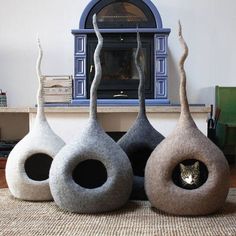 three cat beds sitting in front of a fireplace