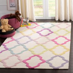 a white rug with pink, yellow and blue trellis on it in front of a window