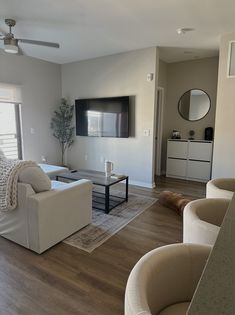 a living room filled with furniture and a flat screen tv mounted to the side of a wall