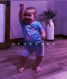 a small child standing on the floor in front of a mirror with one hand up