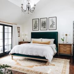 a bedroom with a bed, dresser and chandelier