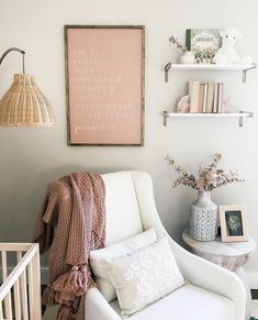 a white chair sitting in front of a baby crib next to a book shelf