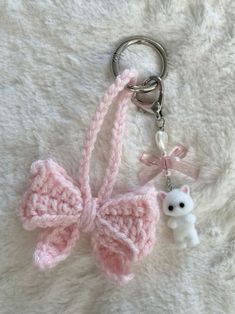 a pink crocheted key chain with a small white teddy bear