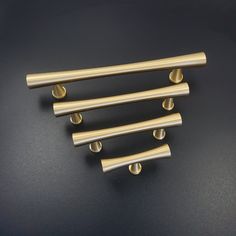 four brass handles on a black surface