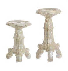 two white glass pedestals sitting next to each other