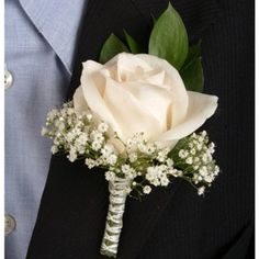 a boutonniere with white roses and baby's breath on the lapel