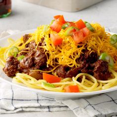 a white plate topped with spaghetti and meat