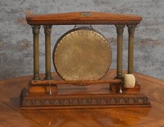 an old time clock sitting on top of a wooden table