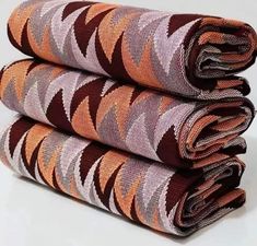 three pieces of cloth are stacked on top of each other, one is brown and the other is orange