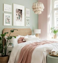 a bedroom with green walls and pictures on the wall above the bed, along with a wicker headboard