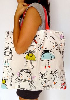 a woman carrying a white bag with cartoon drawings on it