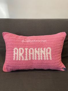 a pink crocheted pillow with the word mama on it sitting on a couch