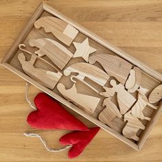 a wooden puzzle in a box with red felt on the floor next to it and an elf's mitt