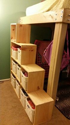 a bunk bed with drawers underneath it and baskets on the bottom shelf next to it