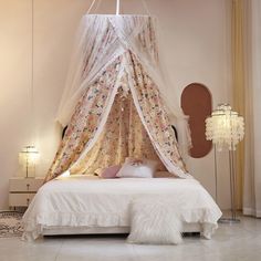 a white bed sitting in a bedroom under a canopy