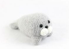 a stuffed seal animal laying on top of a white floor next to a black eye