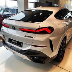 the rear end of a white car in a showroom