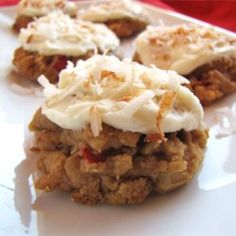 several cookies with white frosting and toppings on a plate