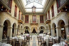 the inside of a building with tables and chairs set up for a formal function in it