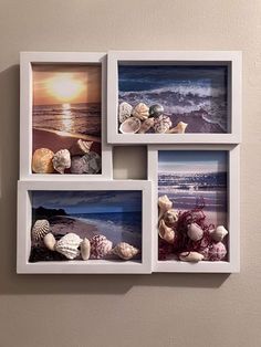 three white frames with seashells in them hanging on a wall next to the ocean