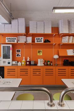 an orange wall in a store with lots of items on the shelves and below them