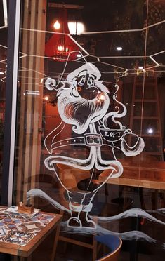 a glass window with a drawing of santa claus on it's face in front of a restaurant