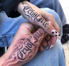 two people with tattoos on their hands holding each other's fingers and the words creative written in cursive writing