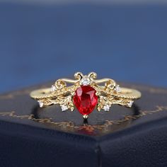 a close up of a ring with a red stone