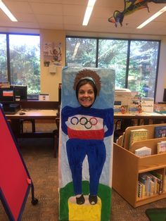 a child's cardboard sculpture in the shape of a person with an olympic symbol on it