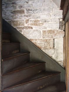 an open door leading up to a set of stairs in a brick walled building