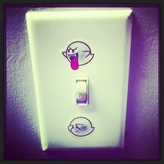 a white light switch with stickers on it's side and an image of a tongue sticking out from its mouth