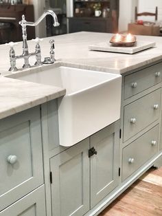 a kitchen with two sinks and an island in the middle is shown, surrounded by wood flooring