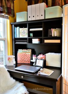 a desk with a laptop, file folders and other office supplies on top of it