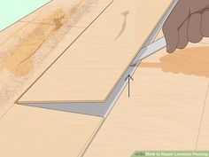 a person cutting wood with a pair of scissors on top of the board and glue