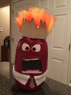 an odd looking red object with a crown on top of it's head, sitting on a counter