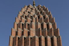 a very tall building with many windows on it's sides and a clock at the top