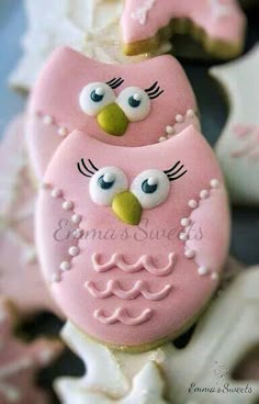 decorated cookies with pink frosting and white icing are arranged in the shape of an owl