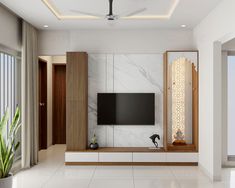 a modern living room with white marble walls and ceiling fan, large flat screen tv mounted on the wall