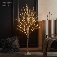 a lighted tree in the corner of a room