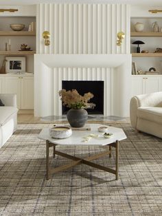 a living room filled with furniture and a fire place in front of a white fireplace