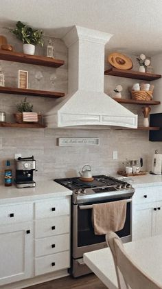 a stove top oven sitting inside of a kitchen next to white cabinets and counter tops