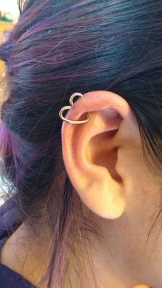 a close up of a person's ear with a ring on top of it