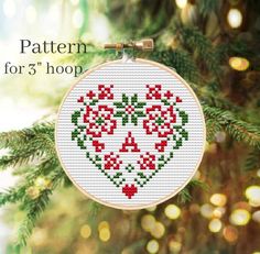 a cross stitch christmas ornament hanging from a tree