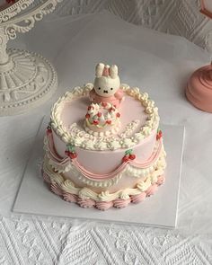 there is a cake that has been decorated with an animal on the top and pink frosting