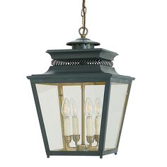 an outdoor hanging light with three lights on it's sides and two candles in the middle