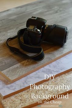 a camera sitting on top of a wooden table with the words diy photography background on it