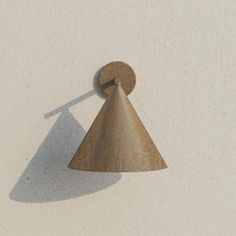 a wall mounted light on the side of a building with a shadow cast on it