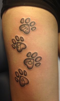 a dog paw tattoo on the side of a woman's leg, which has four paws