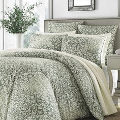 a bed with green and white comforters in a room