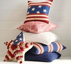 a stack of pillows and blankets with an american flag on them in front of a white wall